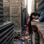 woman leaning on top building rail during daytime